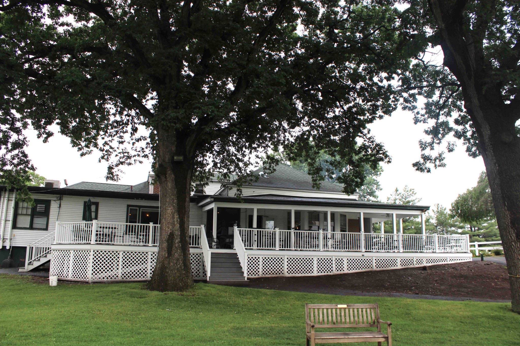 Avant Contracting - Expansive white deck on a country club building, viewed from the lawn.