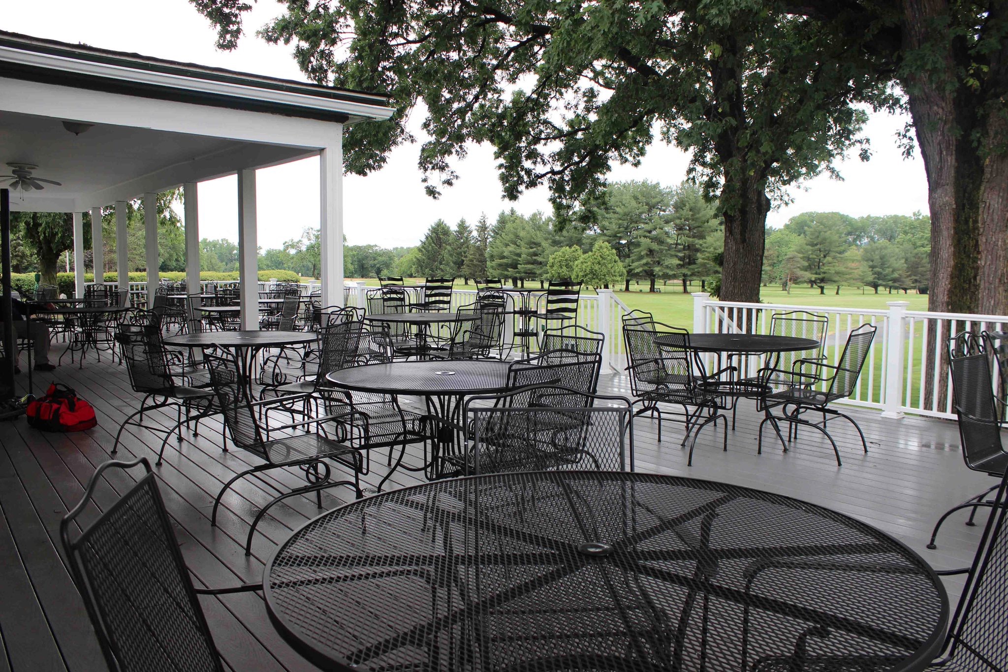 Avant Contracting - View of the country club deck with outdoor seating overlooking the grounds.