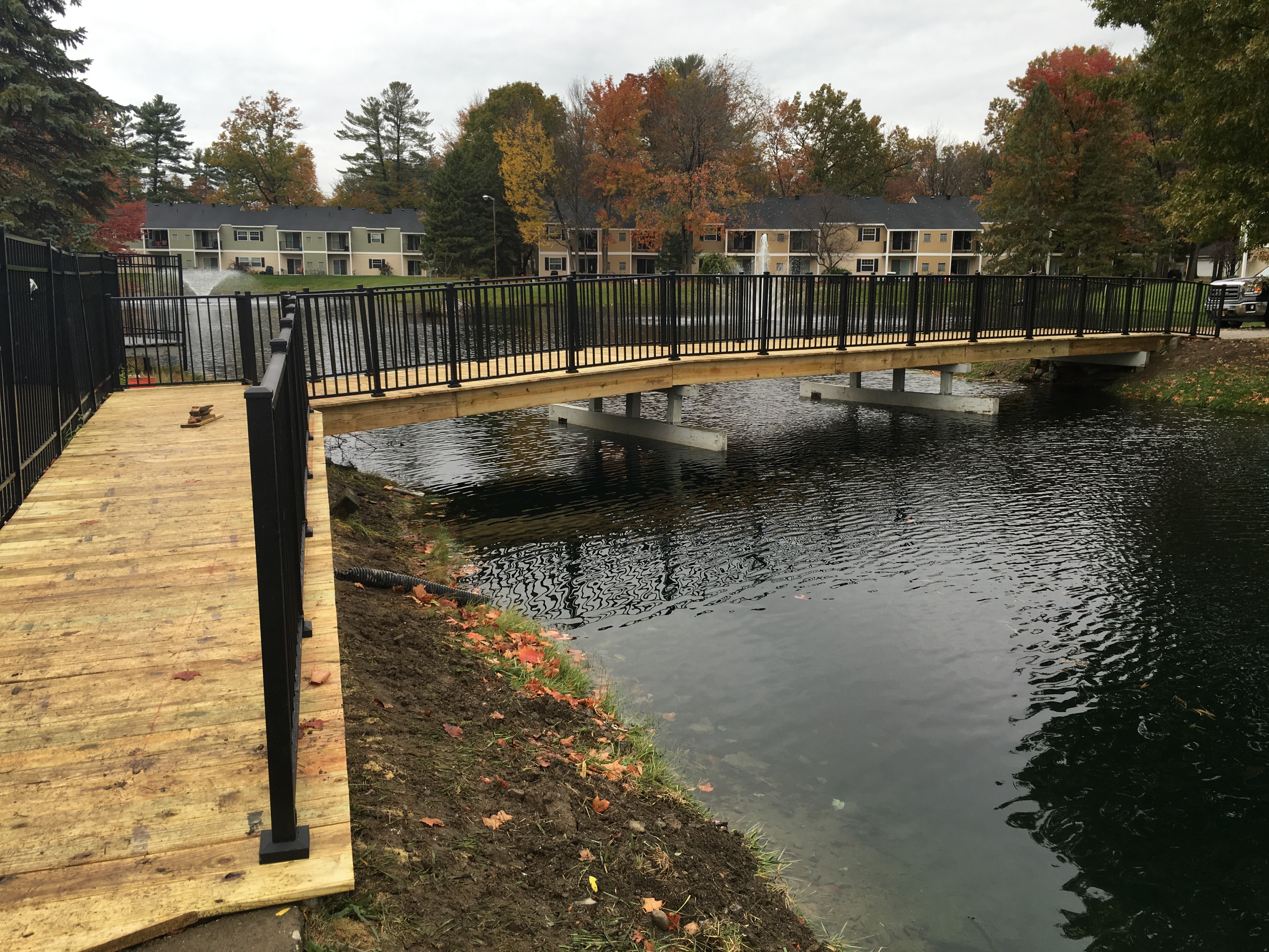 Avant Contracting - Newly constructed wooden deck-bridge over water at an apartment complex.