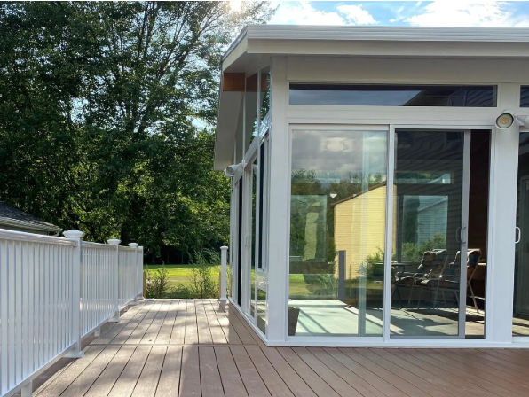 Avant Contracting - Modern sunroom addition with large windows connected to a composite deck.
