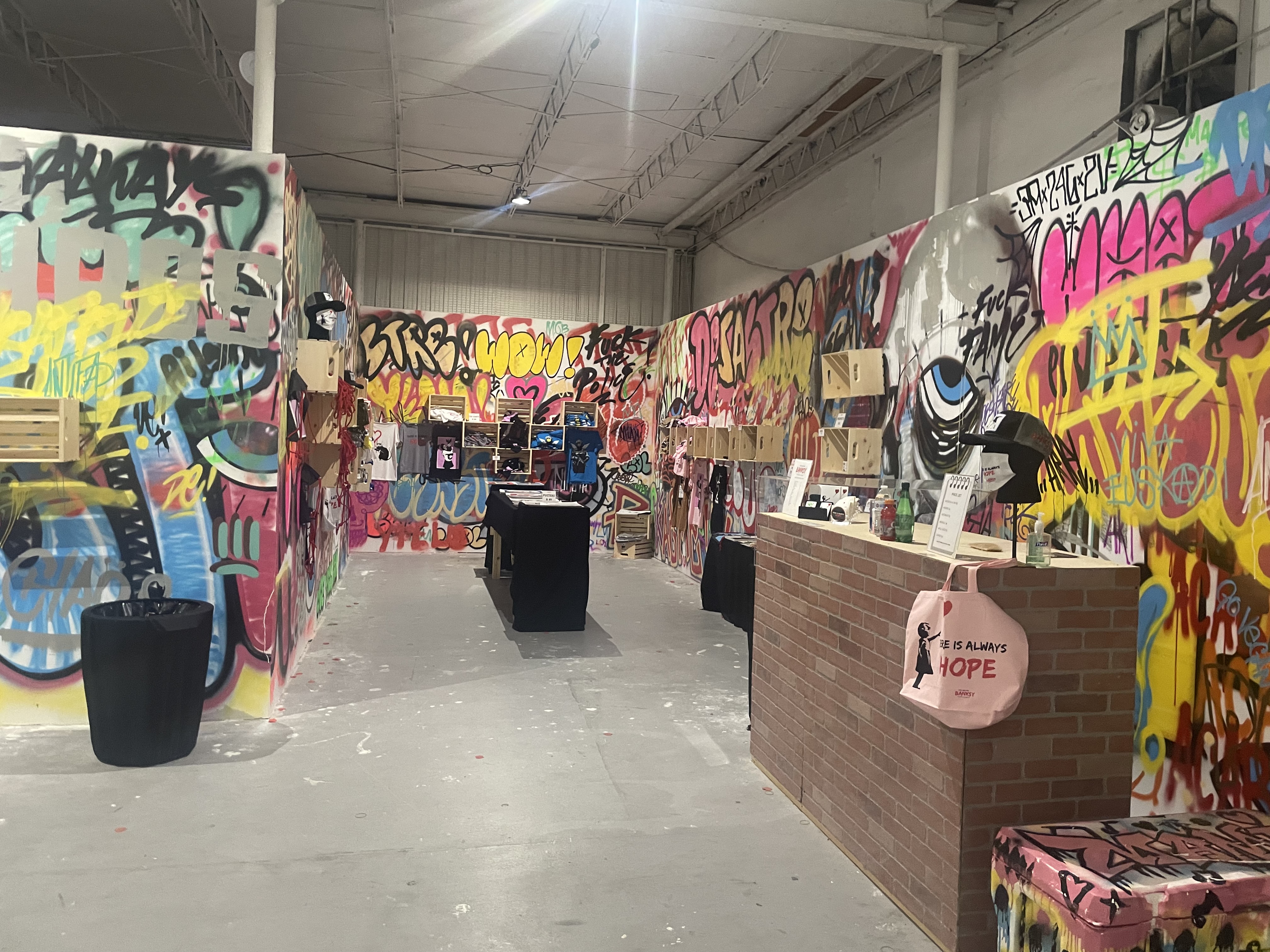 Art of Banksy exhibit - Gift shop area with graffiti-covered walls