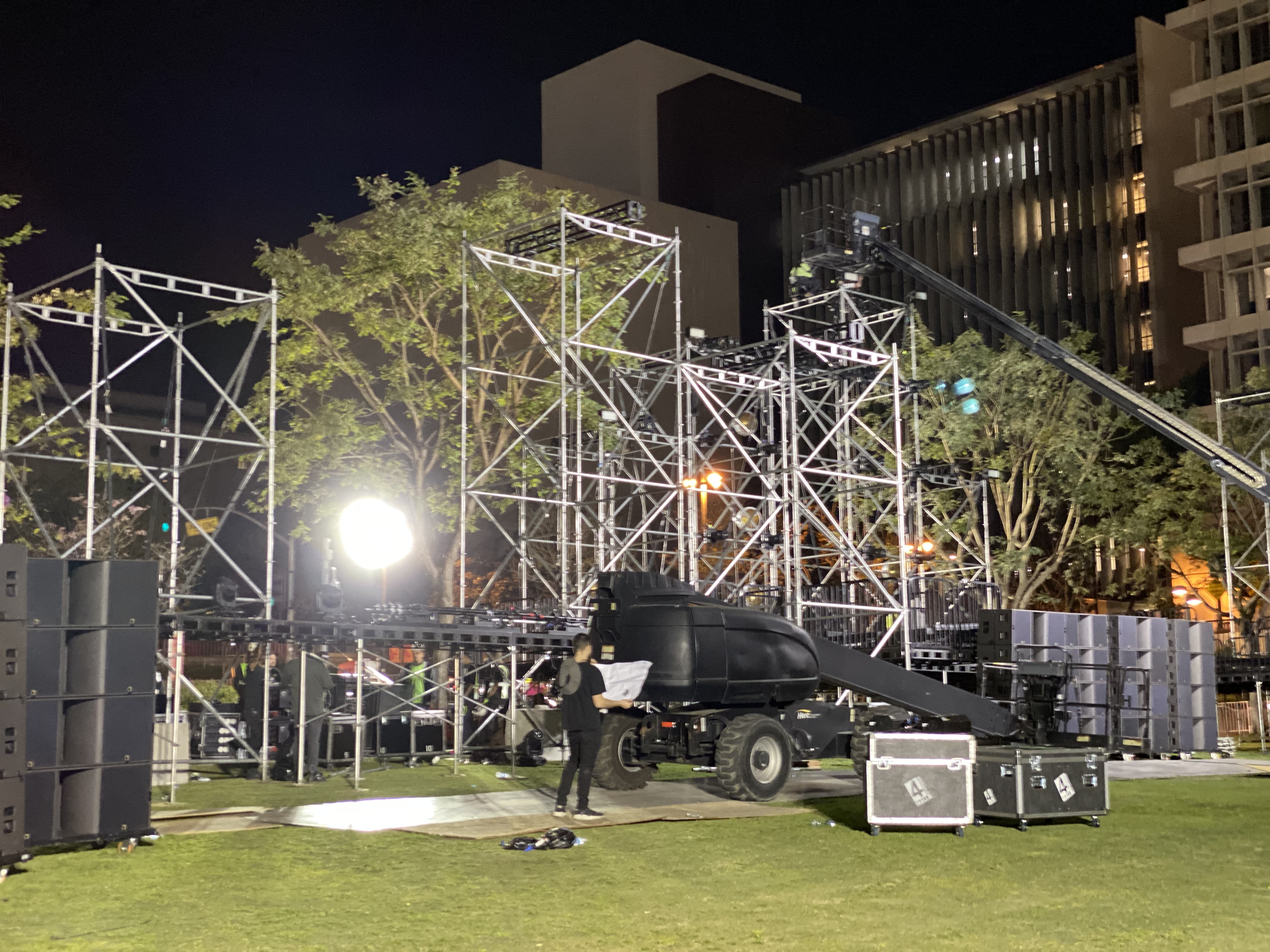 Nighttime outdoor event setup with lighting and speakers