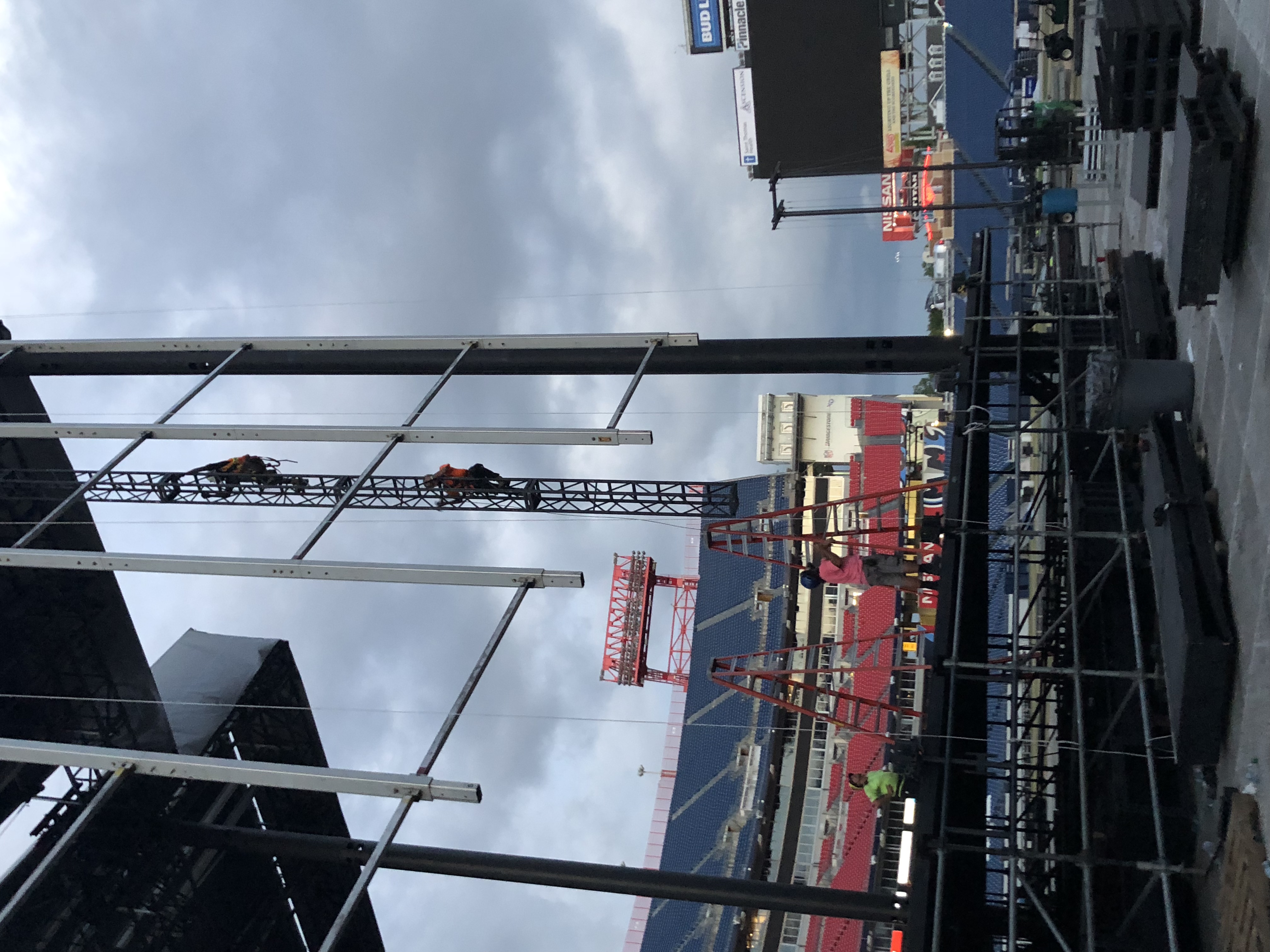 Workers on a tall truss structure installing equipment